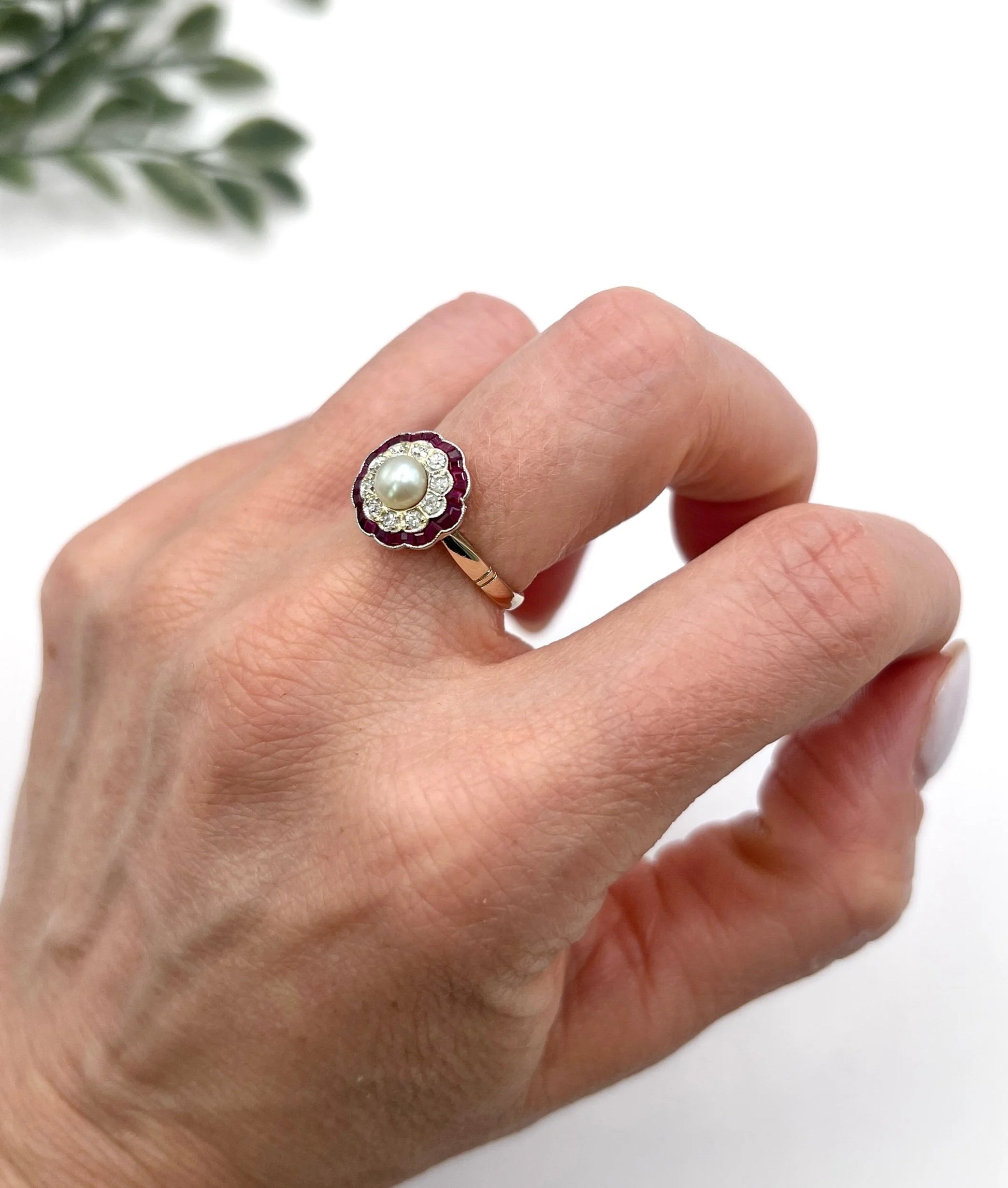 A pearl, diamond and ruby fancy cluster ring in platinum and yellow gold, modelled on a hand