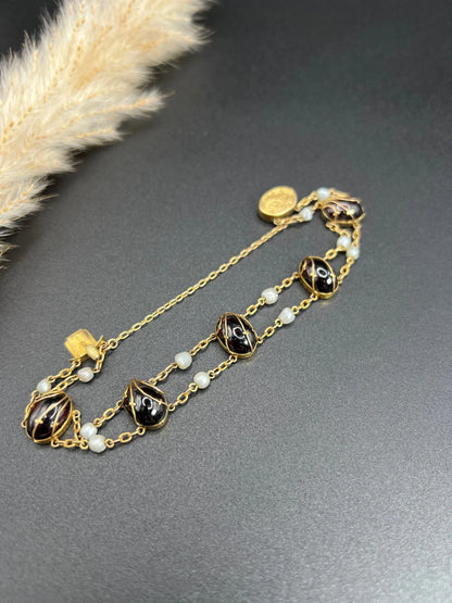 A yellow gold bracelet with oval cabochon garnets and white pearls