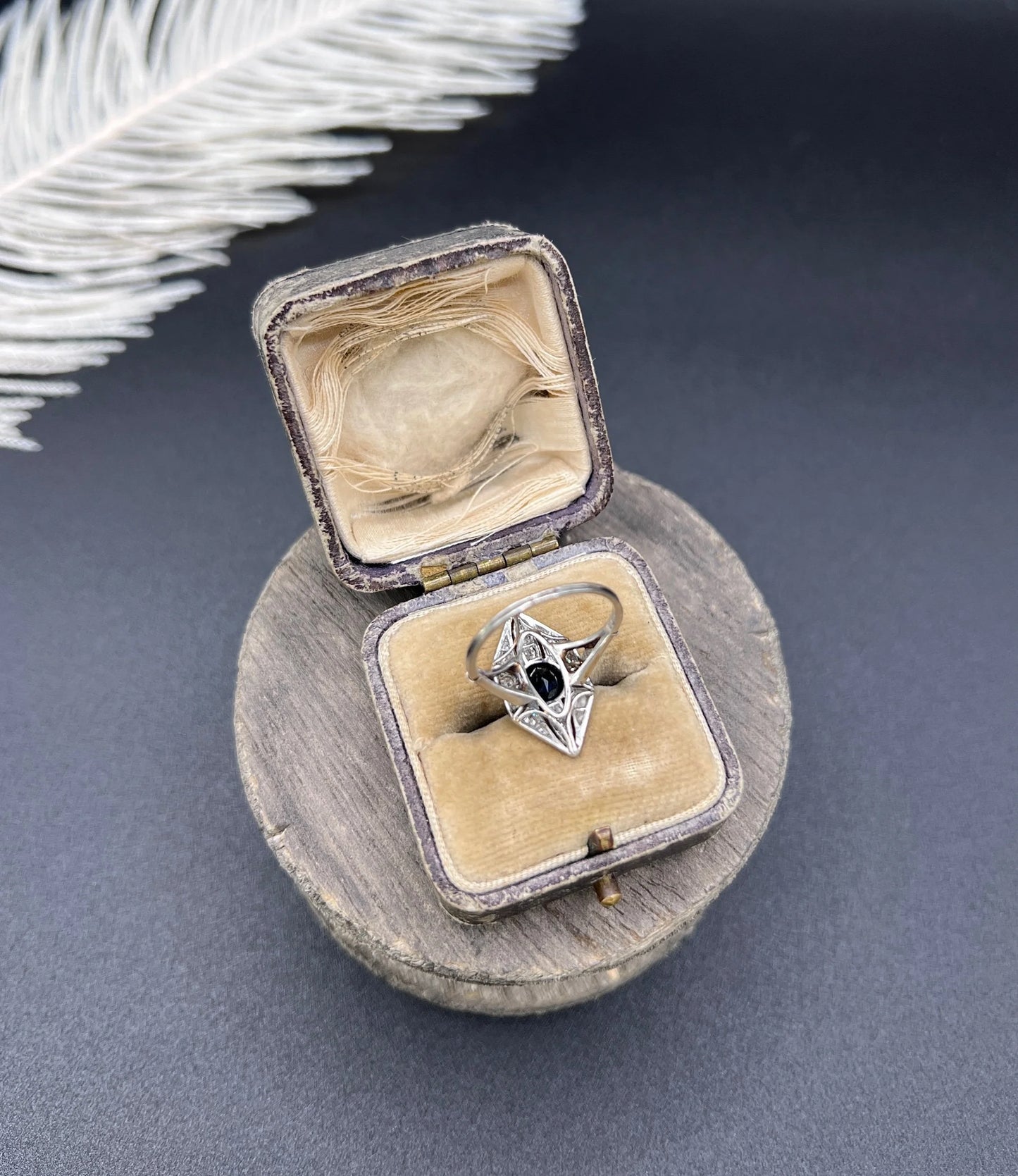 A navette shaped cluster cocktail ring with a sapphire centre surrounded by diamonds, in platinum, in a ring box