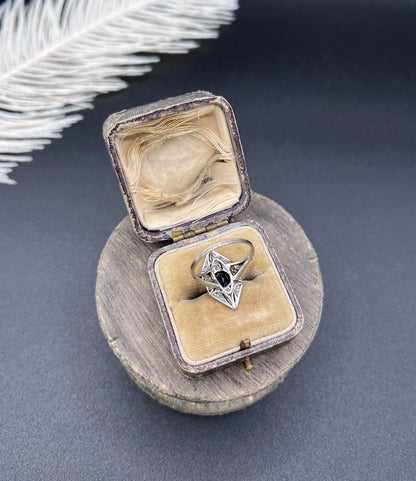 A navette shaped cluster cocktail ring with a sapphire centre surrounded by diamonds, in platinum, in a ring box