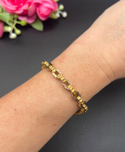 A fancy link yellow gold bracelet modelled on a wrist