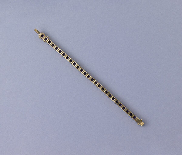 Modern Amethyst Line Bracelet; set with 29 round faceted deep purple amethysts. Mounted in 14ct yellow gold.