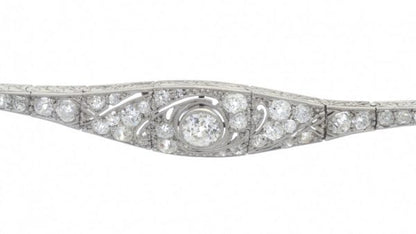 Belle Epoque Diamond and Platinum Bracelet; set with 1.20 carat old-cut diamonds, articulated links with scrolled detail to sides, Circa 1910