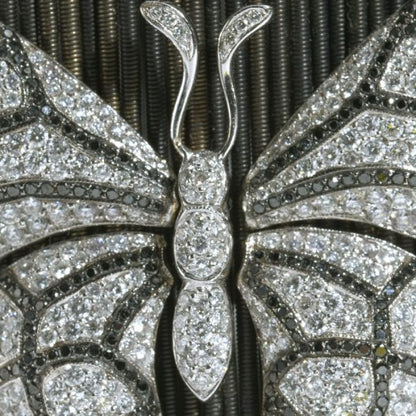 Diamond Butterfly and Ladybird Cuff Bracelet, set with 9.00 carats of white and black diamonds on anodised white gold twisted bars on sprung fittings