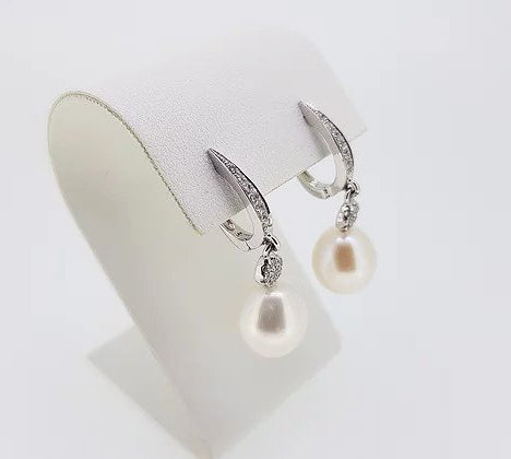 Pearl and Diamond Drop Earrings; featuring pearls suspended from diamond set hoops via diamond clusters. Mounted in 18ct white gold.