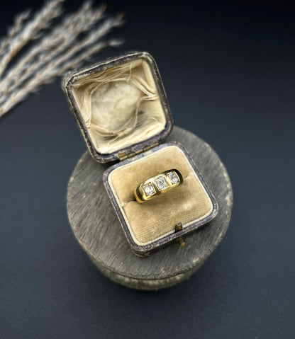 A three stone old cut diamond ring in yellow gold, in an antique ring box
