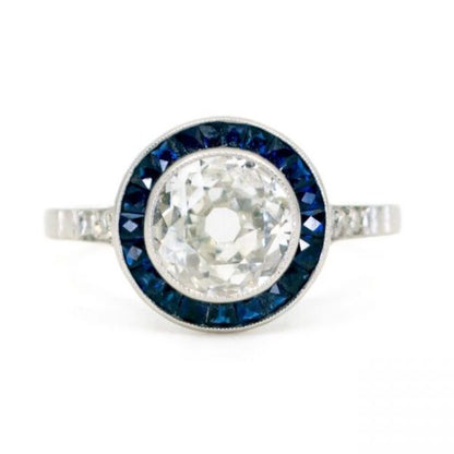 Art Deco Diamond and Sapphire Target Ring; central 1.23 carat old mine-cut diamond with calibre sapphire surround and single-cut diamond-set shoulders, in platinum