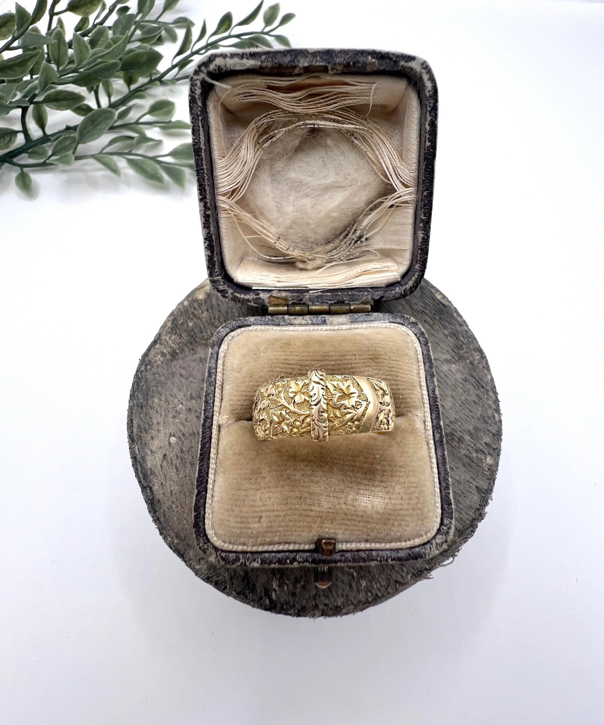 A yellow gold ornate engraved buckle band ring, in an antique rng box