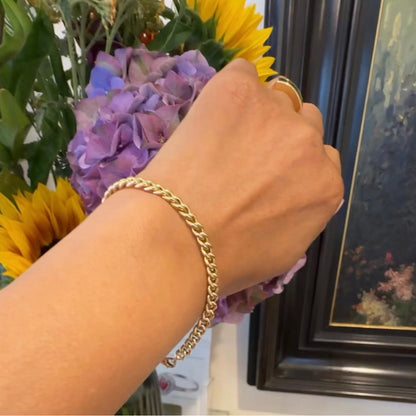 A yellow gold curb link bracelet, modelled on a wrist