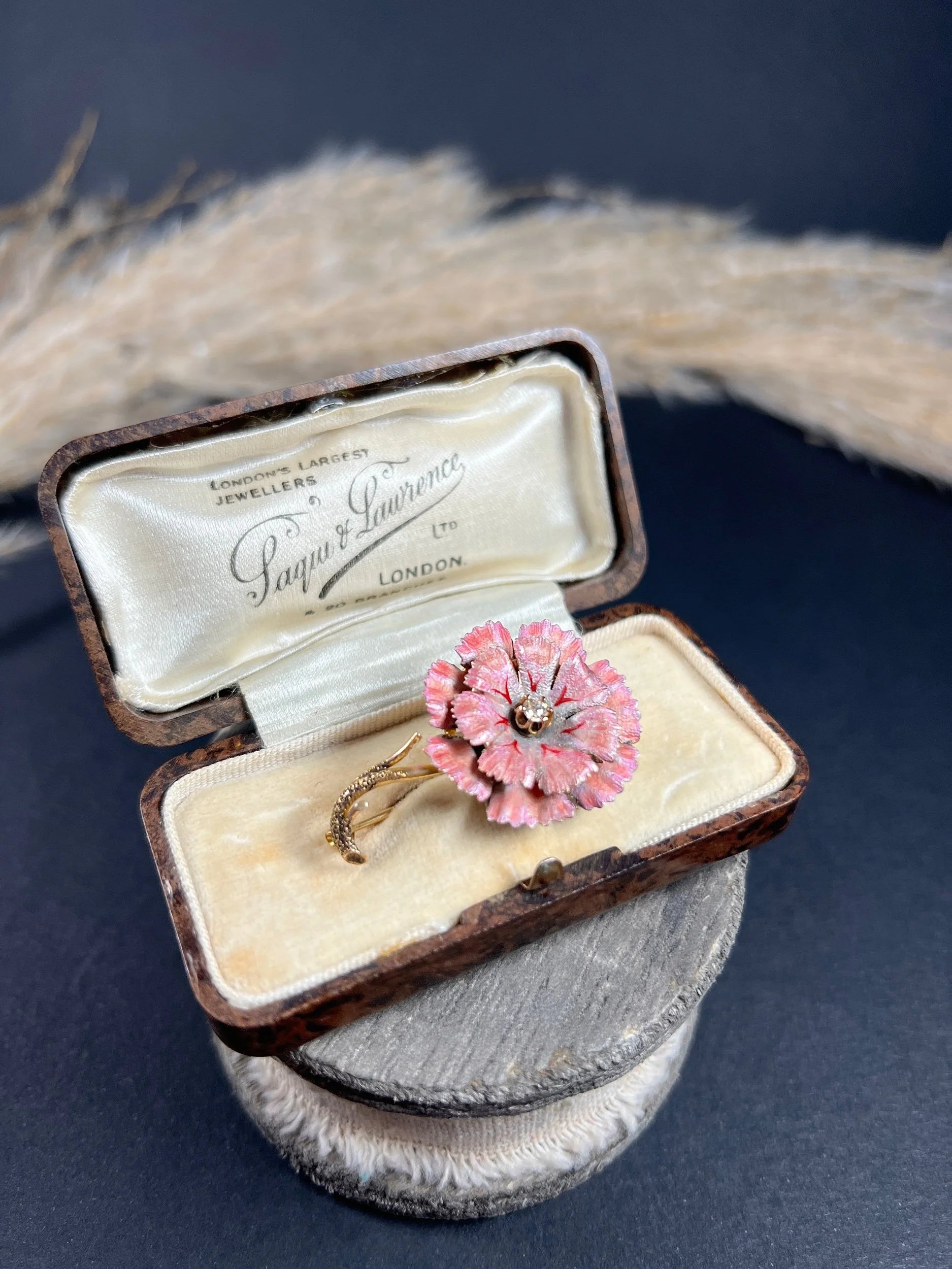 A pink enamelled flower brooch with a diamond centre, in yellow gold, in a box