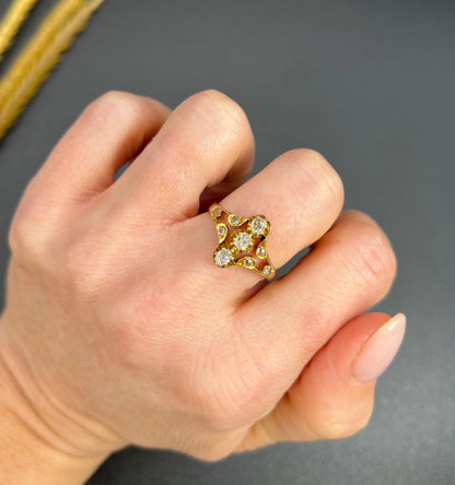 An antique old cut diamond ring in yellow gold, modelled on a hand