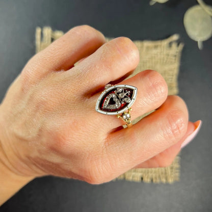 An ornate diamond and enamel navette shaped antique ring, modelled on a hand