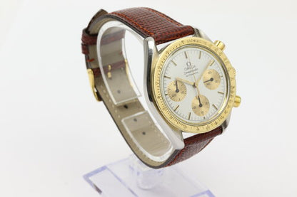 Omega Speedmaster Reduced 39mm Automatic Chronograph in Steel and Gold, white baton dial, yellow gold tachymetre bezel, on red/brown lizard strap with pin buckle.