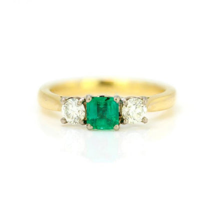 Emerald and Diamond Three Stone Ring; central emerald-cut emerald flanked by brilliant-cut diamonds, in 18ct yellow gold, Circa 2000s