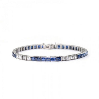 Antique Art Deco Sapphire and Diamond Line Bracelet; alternating pattern of six French-cut sapphires in channel settings and four round brilliant-cut diamonds in box settings. Crafted from platinum, all settings are individually hinged with millegrain edges. The sides are engraved with a millegrain and foliate design. Circa 1935