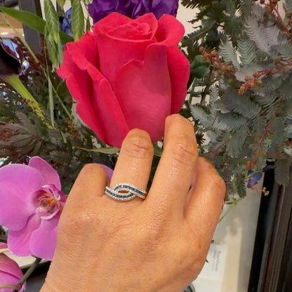 A sapphire and diamond crossover band ring in yellow gold, modelled on a hand