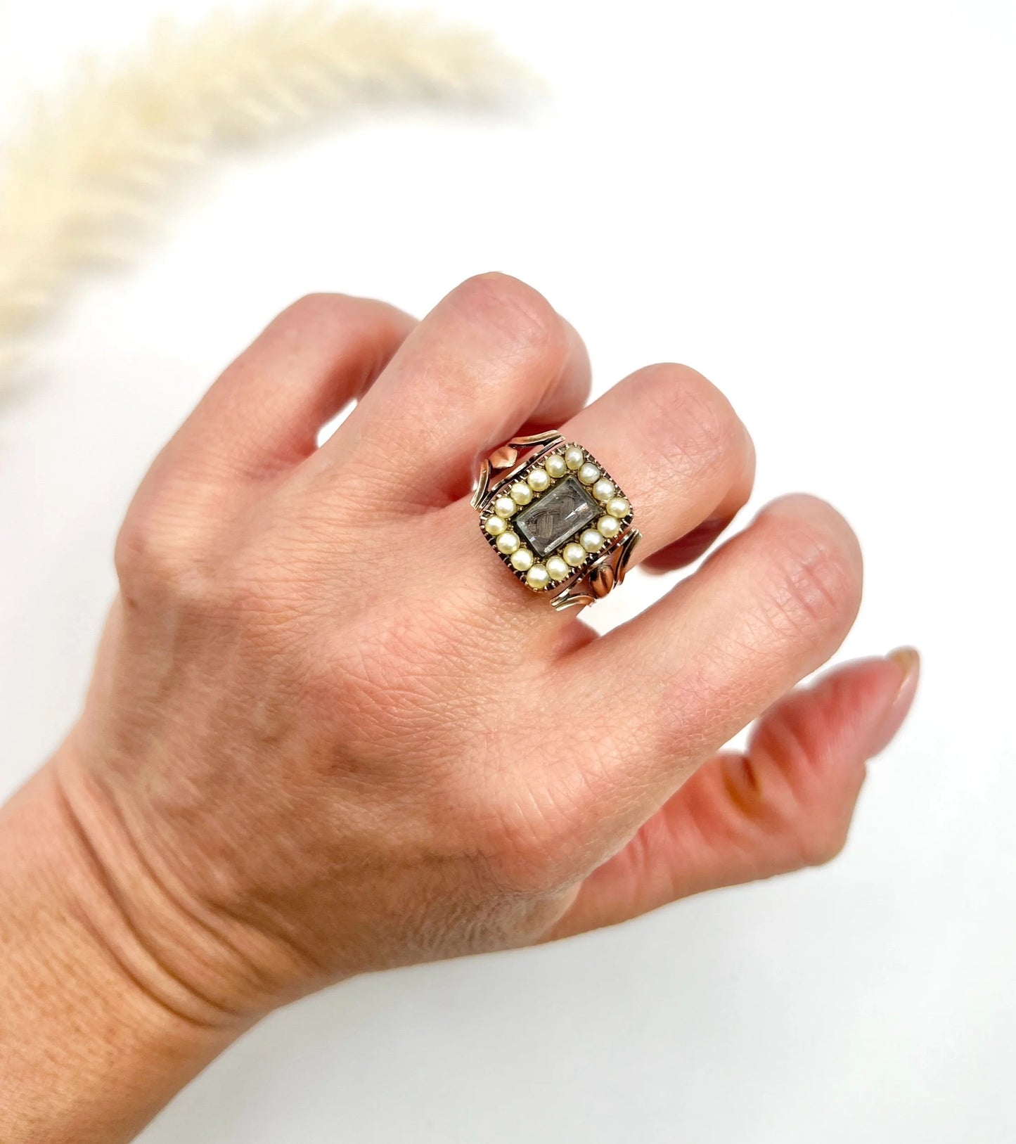 An antique seed pearl mourning ring in gold, modelled on a hand