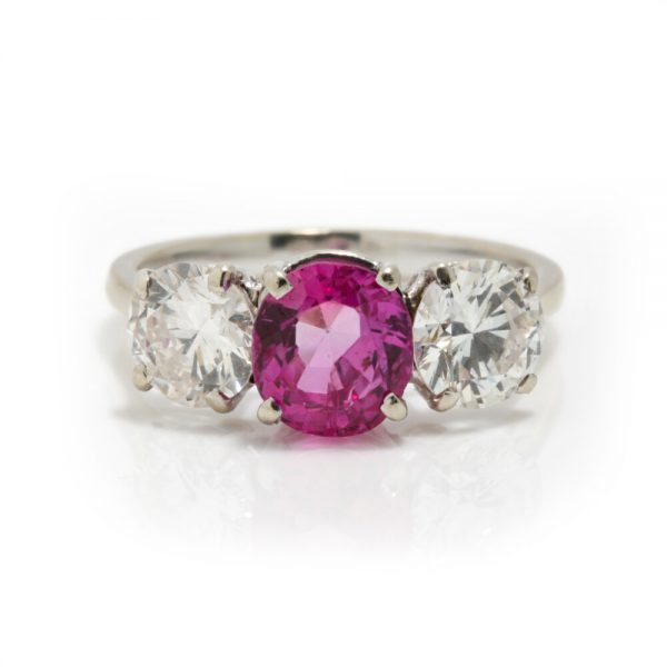 Natural Pink Sapphire and Diamond Three Stone Ring; central 1.50ct natural pink sapphire flanked by 2cts round brilliant-cut diamonds, all claw set in platinum