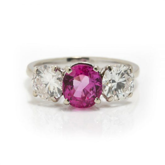 Natural Pink Sapphire and Diamond Three Stone Ring; central 1.50ct natural pink sapphire flanked by 2cts round brilliant-cut diamonds, all claw set in platinum