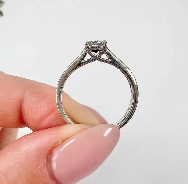 A white gold brilliant cut diamond engagement ring with diamond set shoulders