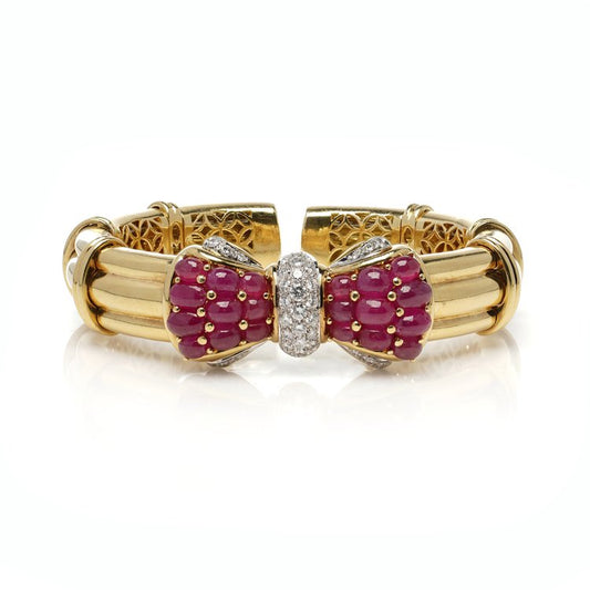 Italian 18ct Yellow Gold Bangle with Burma Ruby and Diamond Bow; set with 8.40 carats cabochon natural Burma rubies and 1.21 carats brilliant-cut diamonds. Circa 1990s