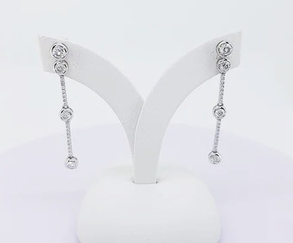 Contemporary Diamond Drops Earrings; featuring bezel set brilliant-cut diamonds linked via smaller diamond set links, 0.70 carat total, 18ct white gold.