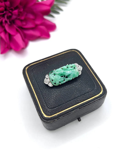 A carved green jade and diamond brooch in white gold