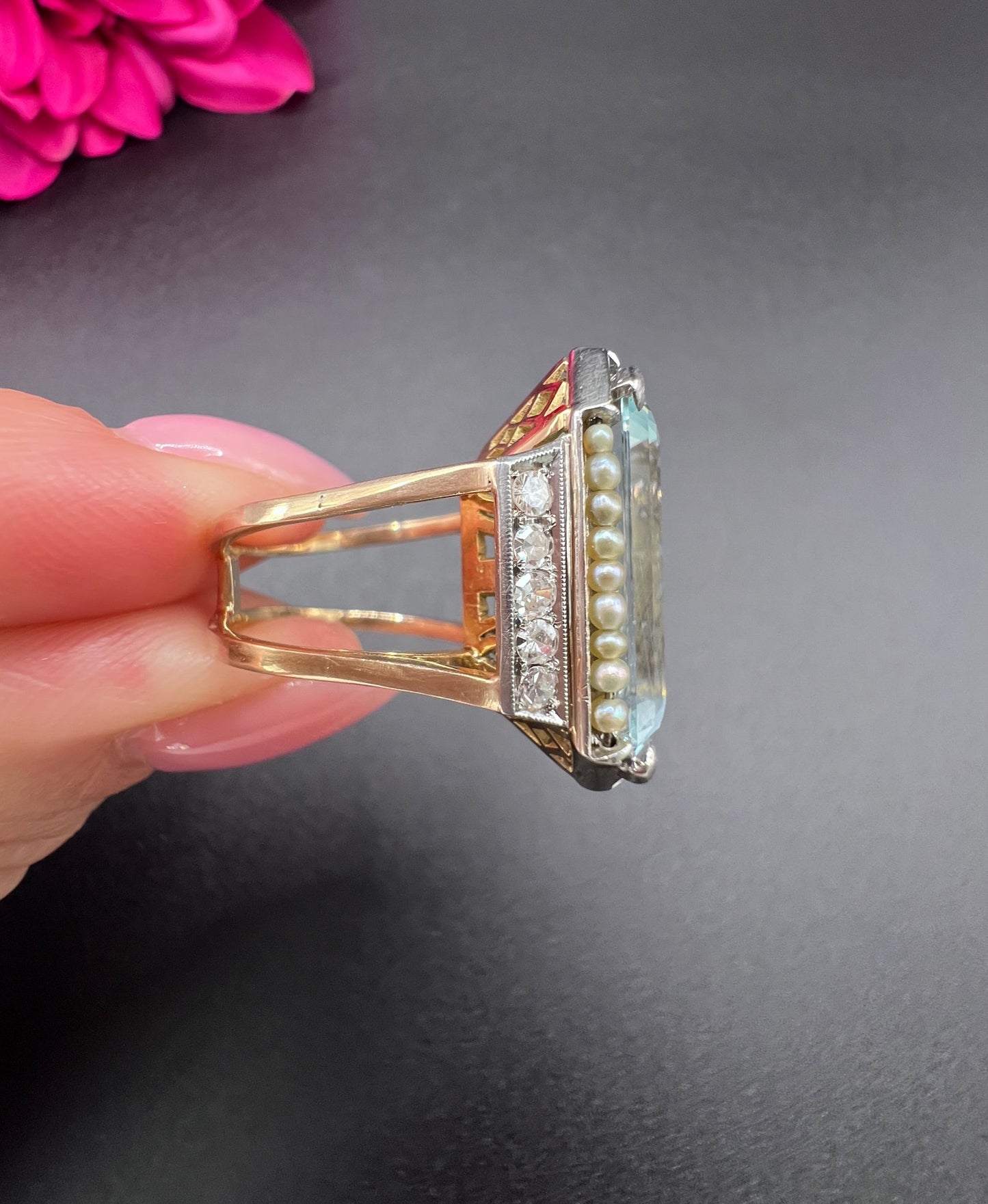 An aquamarine, pearl and diamond large cocktail ring in yellow gold and platinum, held in a hand
