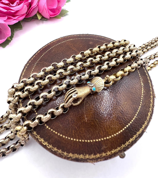A yellow gold long guard chain with a gem-set hand clasp