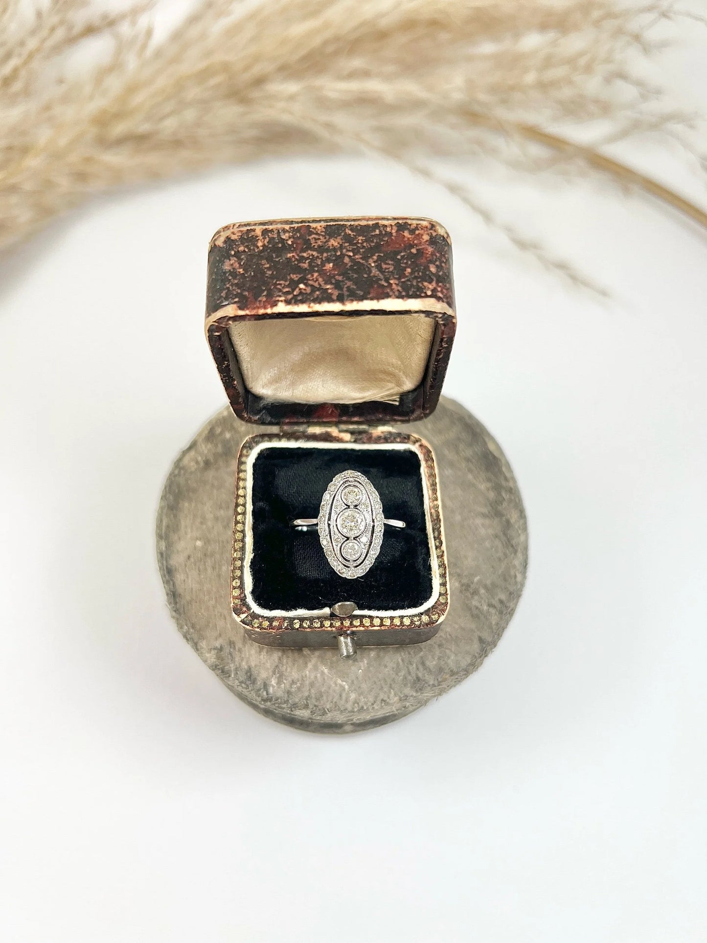 Antique 18 Carat White Gold Three Stone Diamond Oval Halo Ring, Circa 1910