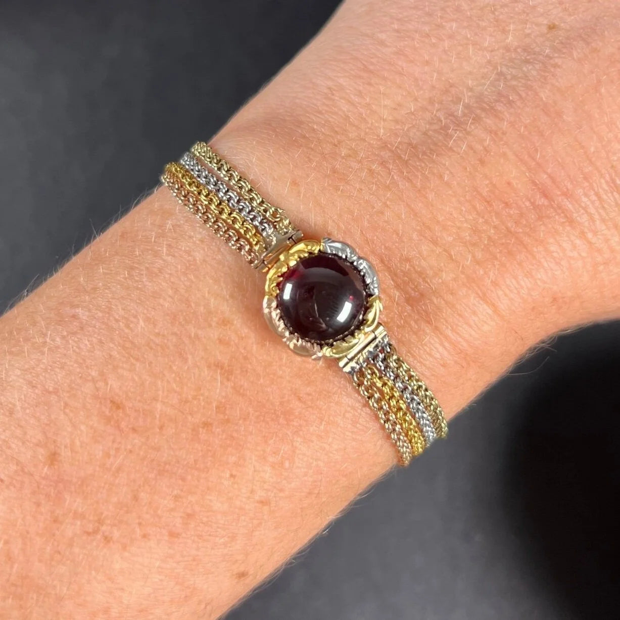 A cabochon garnet bracelet with three colour gold chains, modelled on a wrist