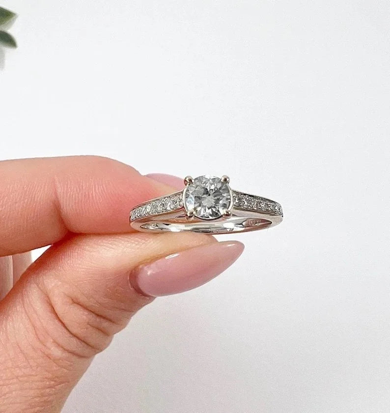 A white gold brilliant cut diamond engagement ring with diamond set shoulders