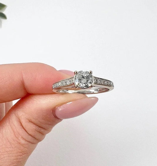 A white gold brilliant cut diamond engagement ring with diamond set shoulders