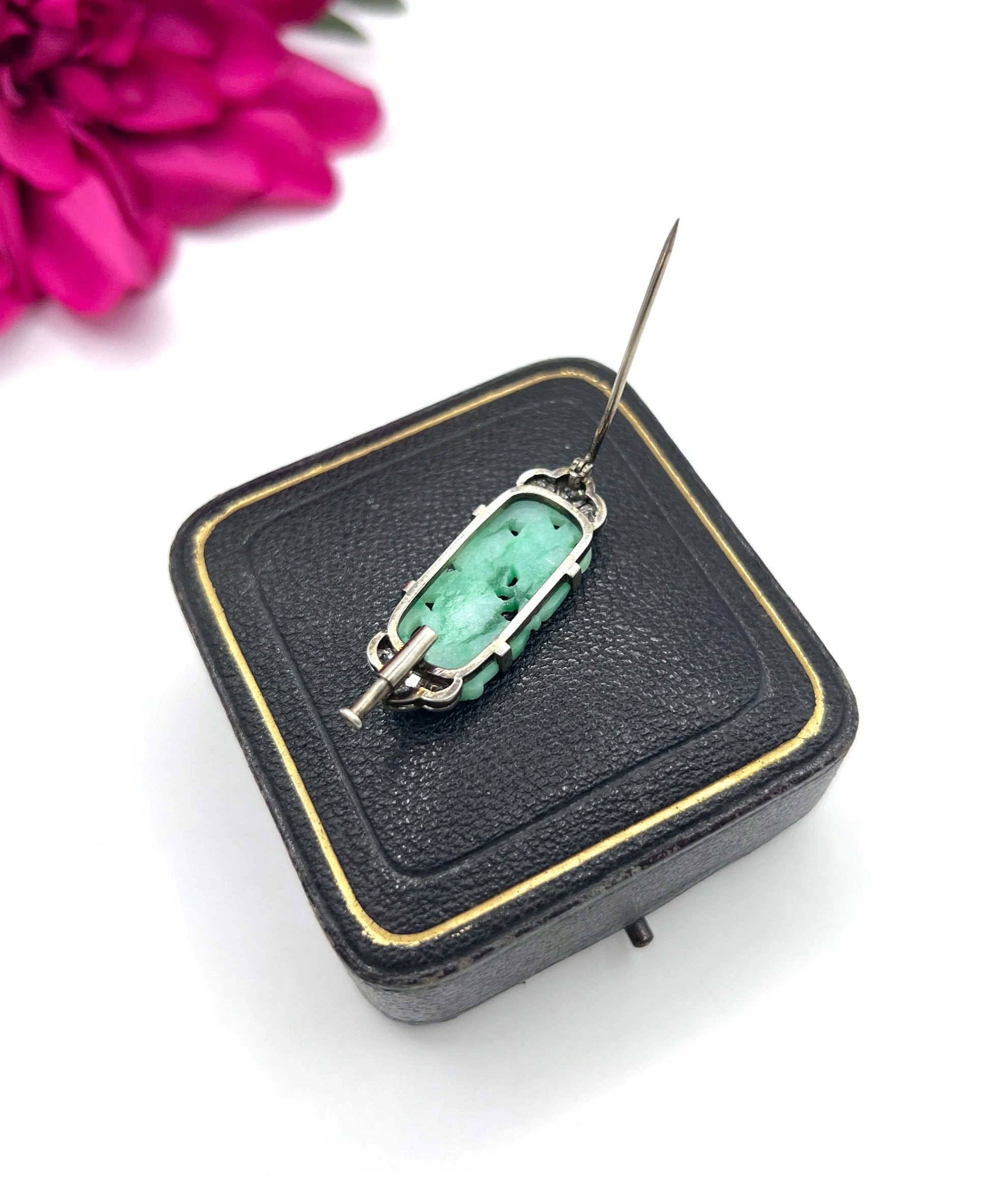 A carved green jade and diamond brooch in white gold