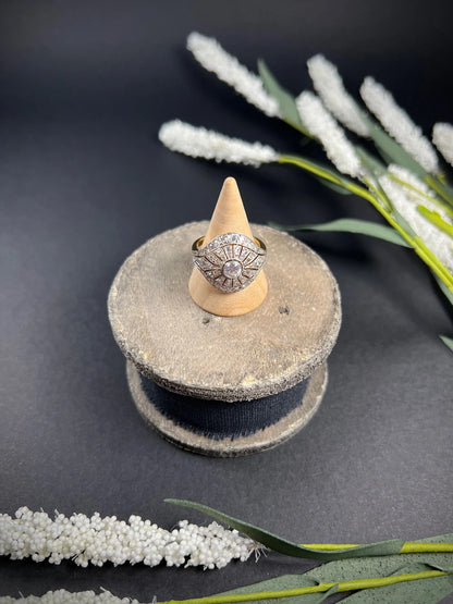 A diamond cocktail ring in yellow and white metal, on a ring cone