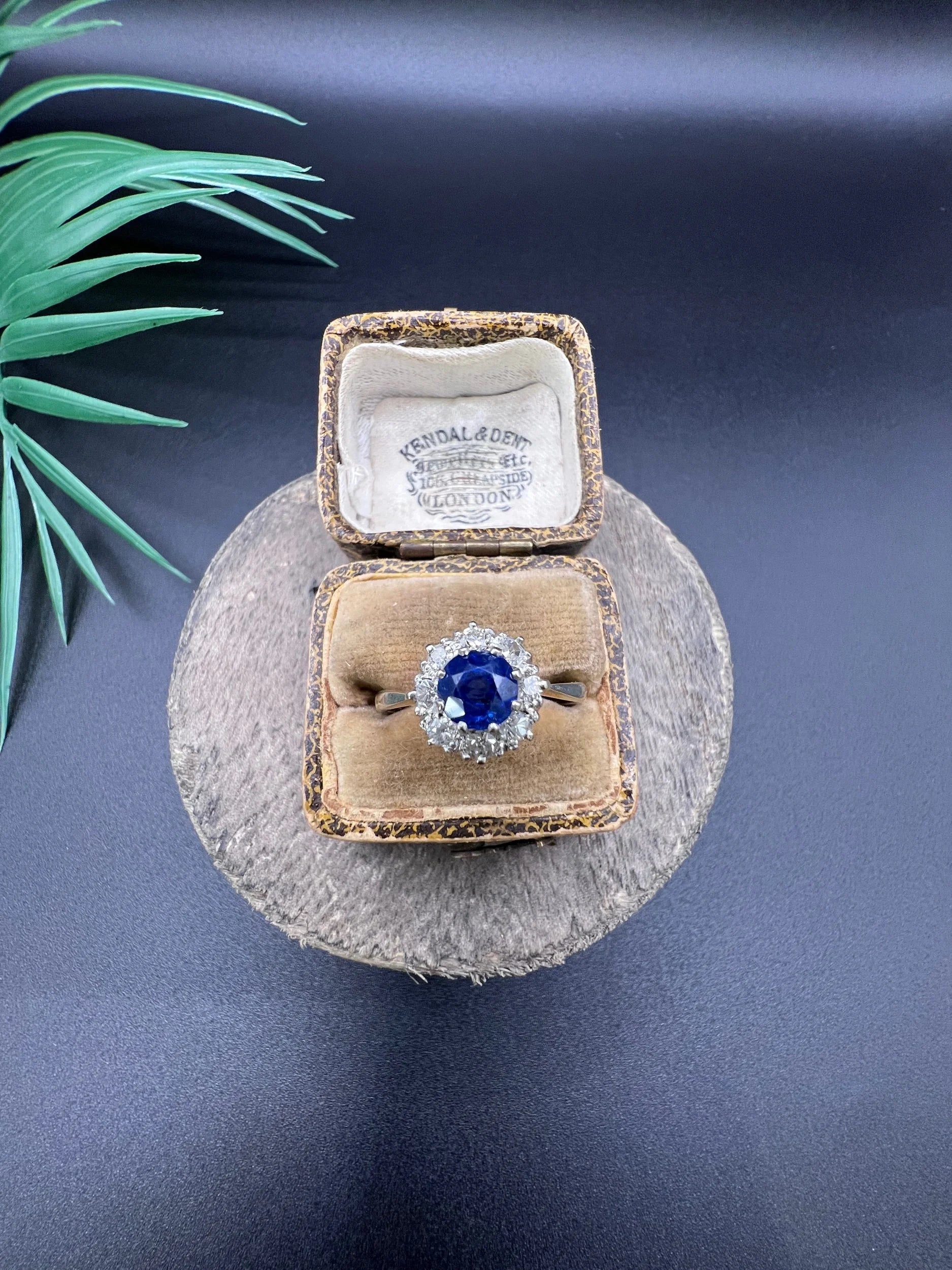 A circular cluster ring with sapphire and diamonds in yellow gold and platinum, in an antique ring box
