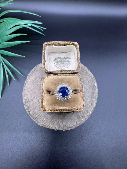 A circular cluster ring with sapphire and diamonds in yellow gold and platinum, in an antique ring box