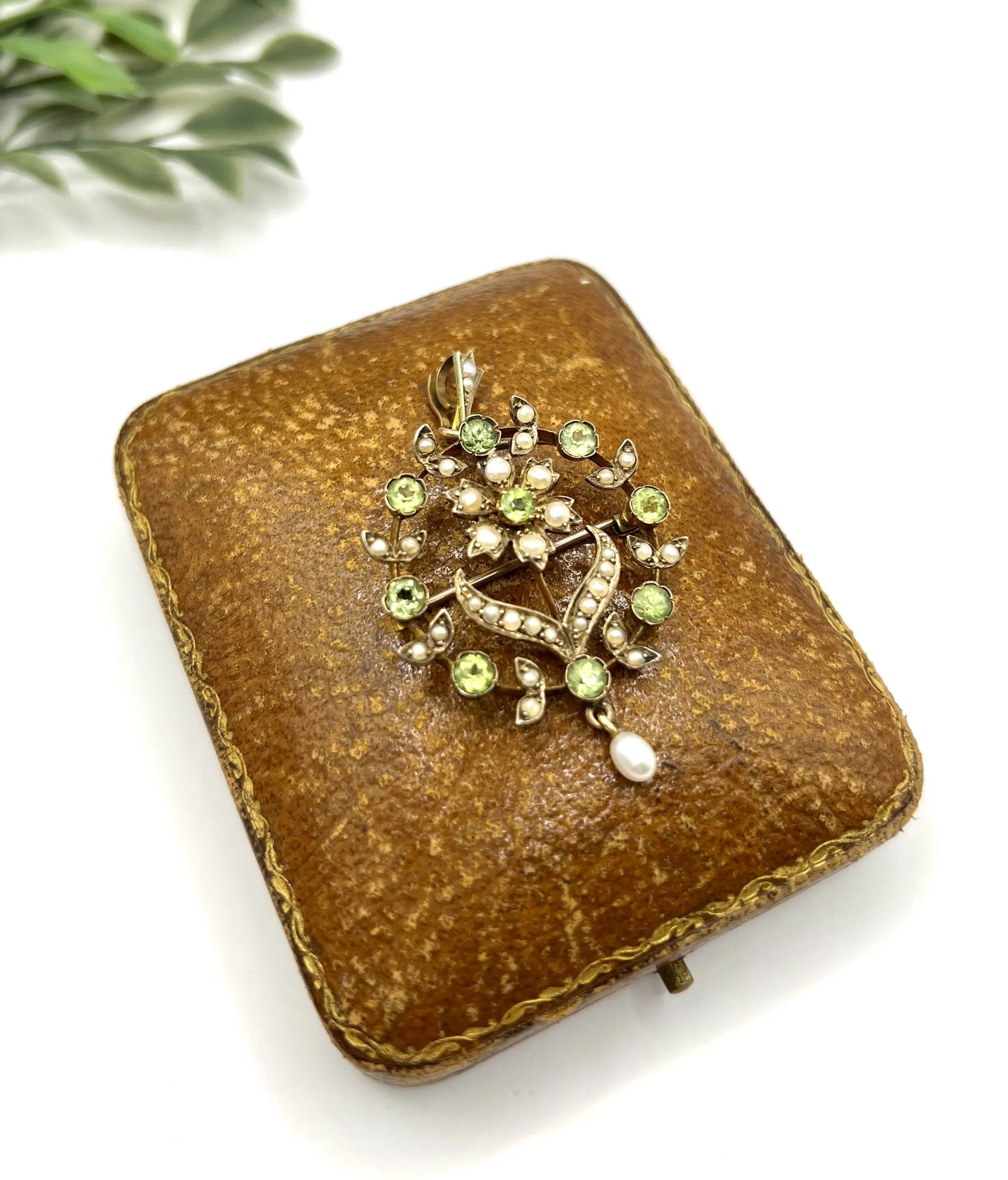 A peridot and pearl floral circle brooch/pendant in yellow gold