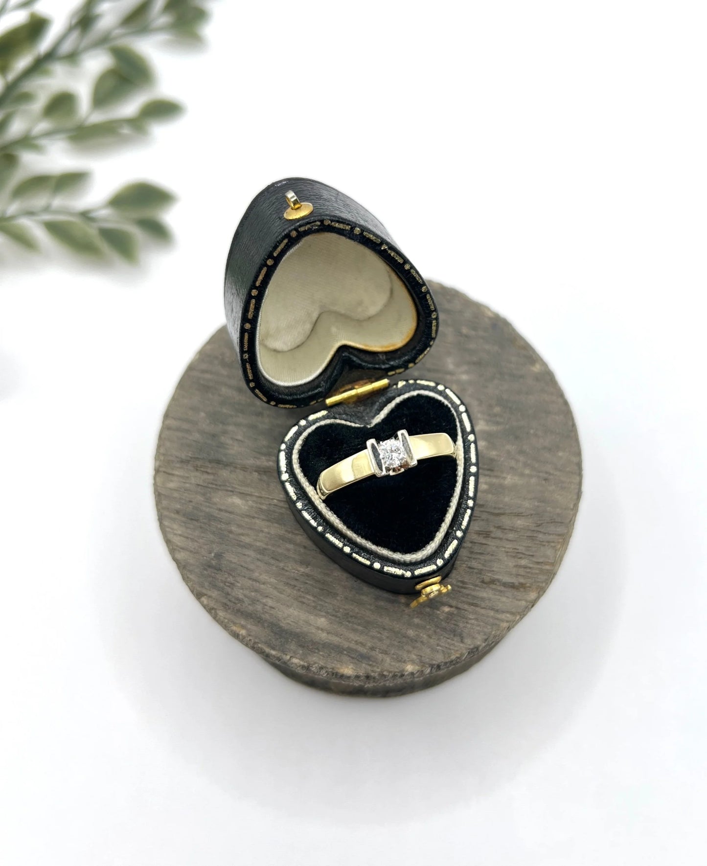 A brilliant cut diamond solitaire ring in yellow gold, in a heart-shaped ring box