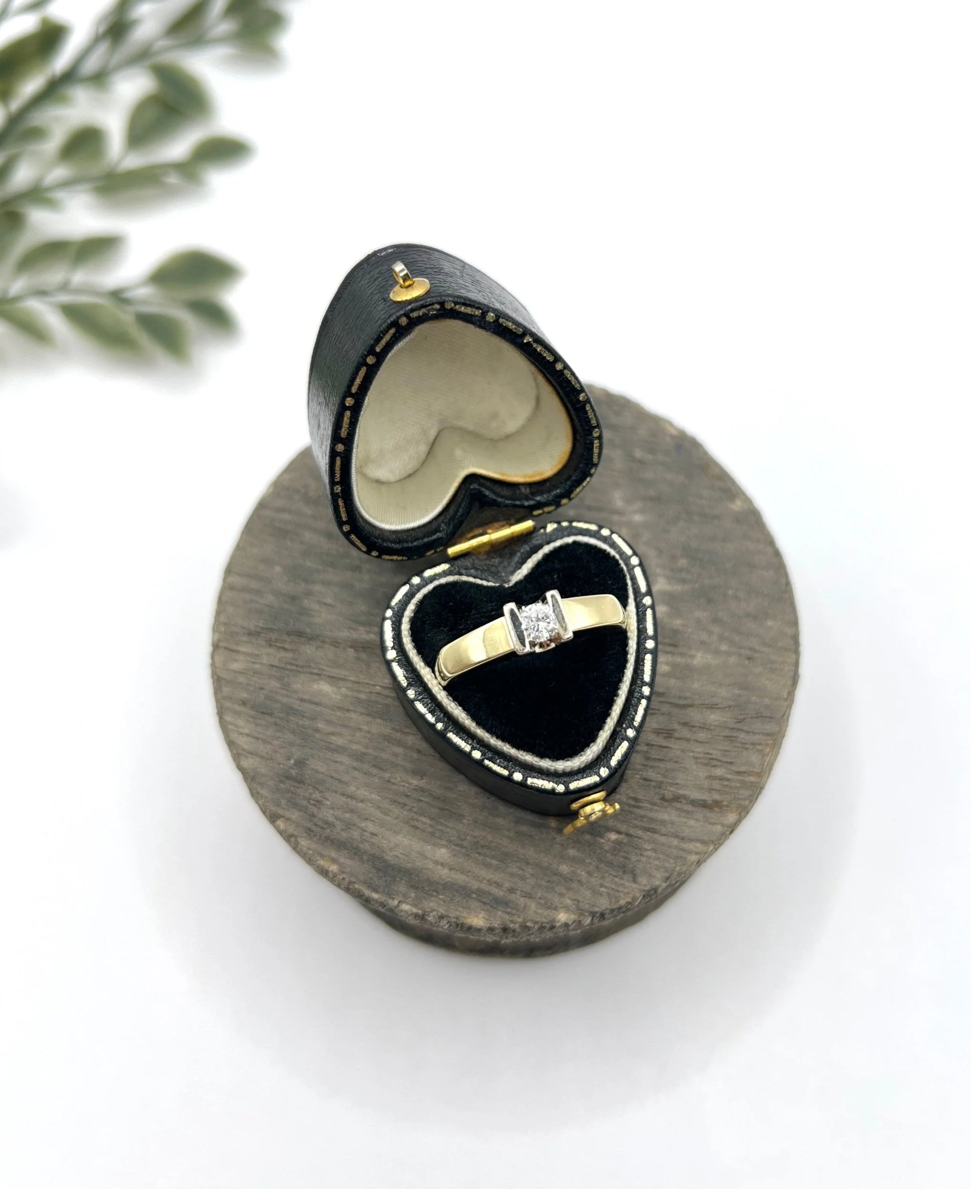 A brilliant cut diamond solitaire ring in yellow gold, in a heart-shaped ring box