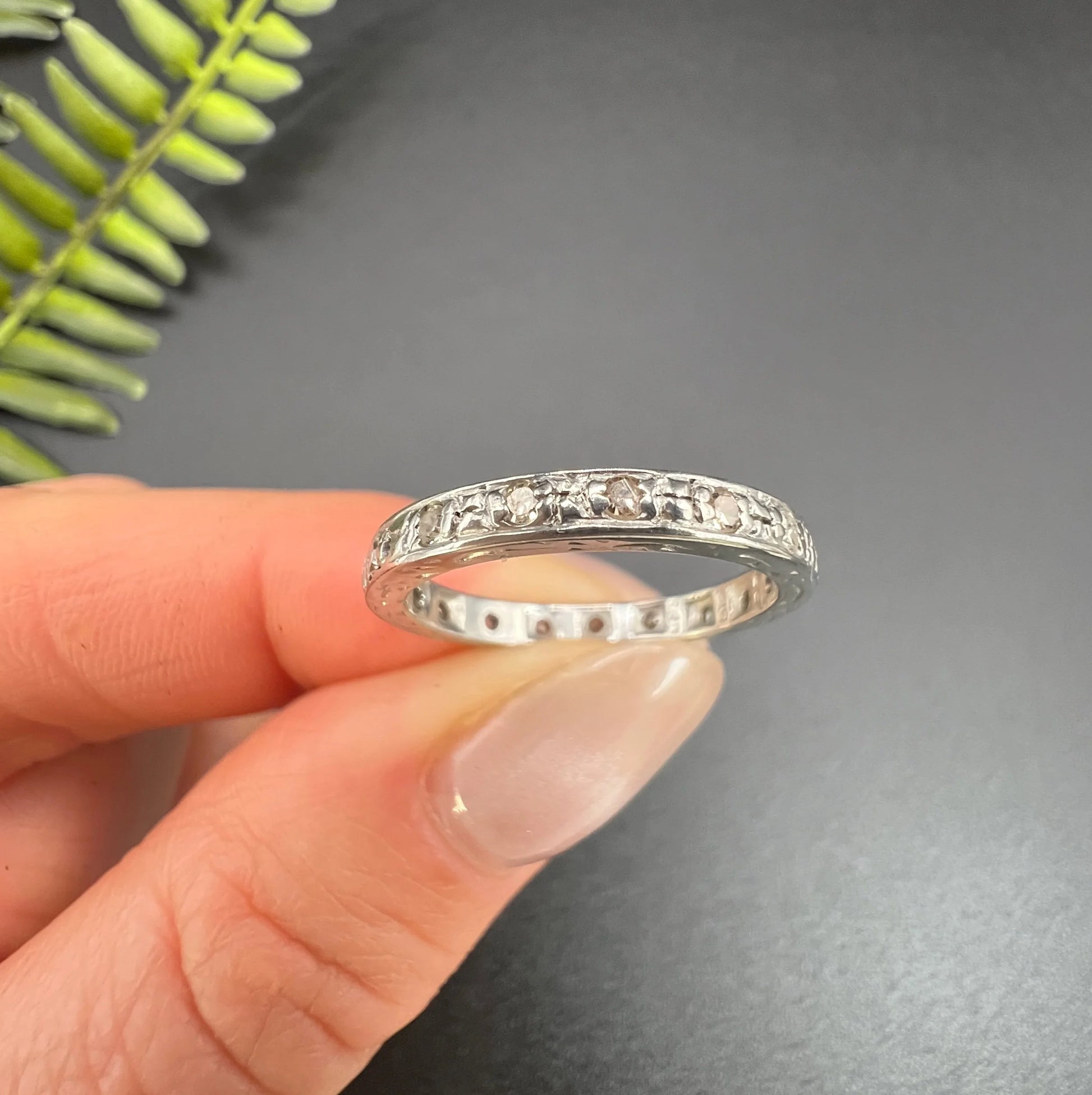 A diamond full eternity ring in white gold, held in a hand