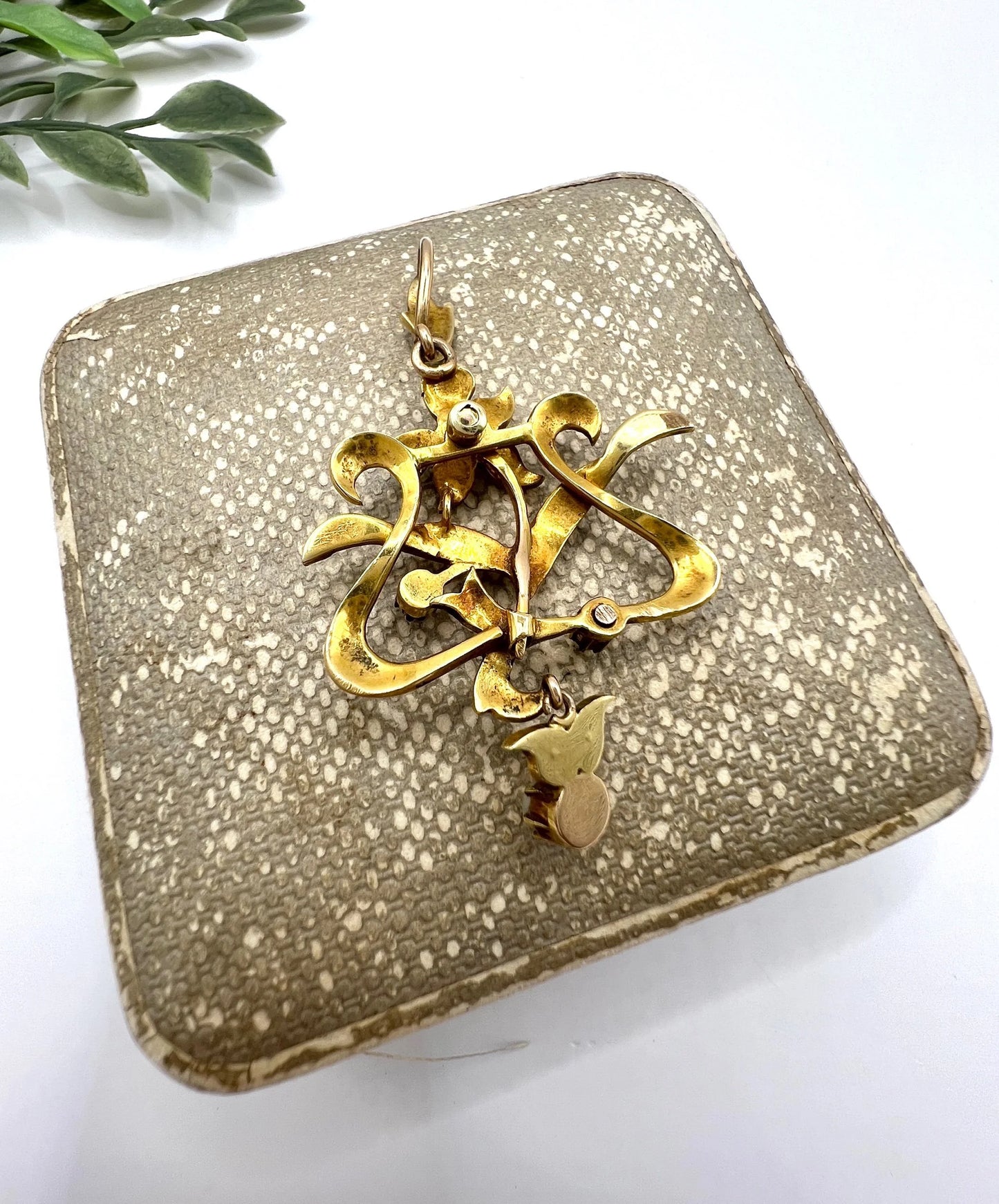 A floral pendant in yellow gold with seed pearls and red enamel