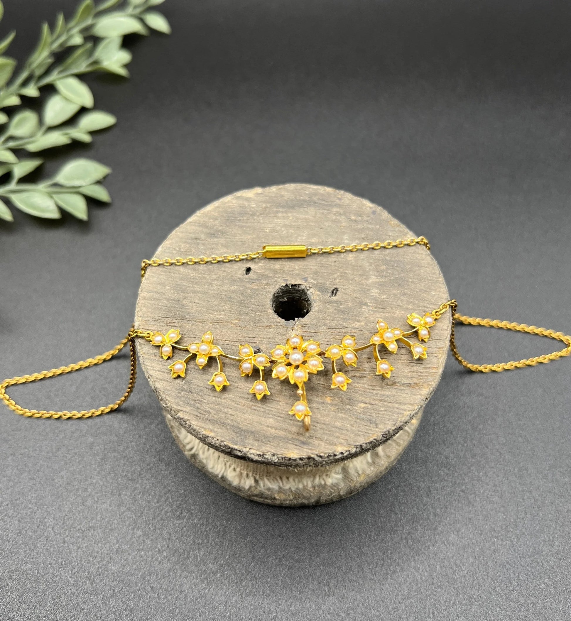 A yellow gold floral pendant necklace with seed pearls