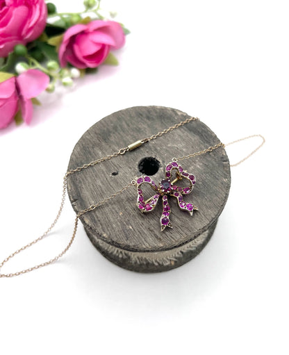 A ruby bow brooch necklace in gold and silver
