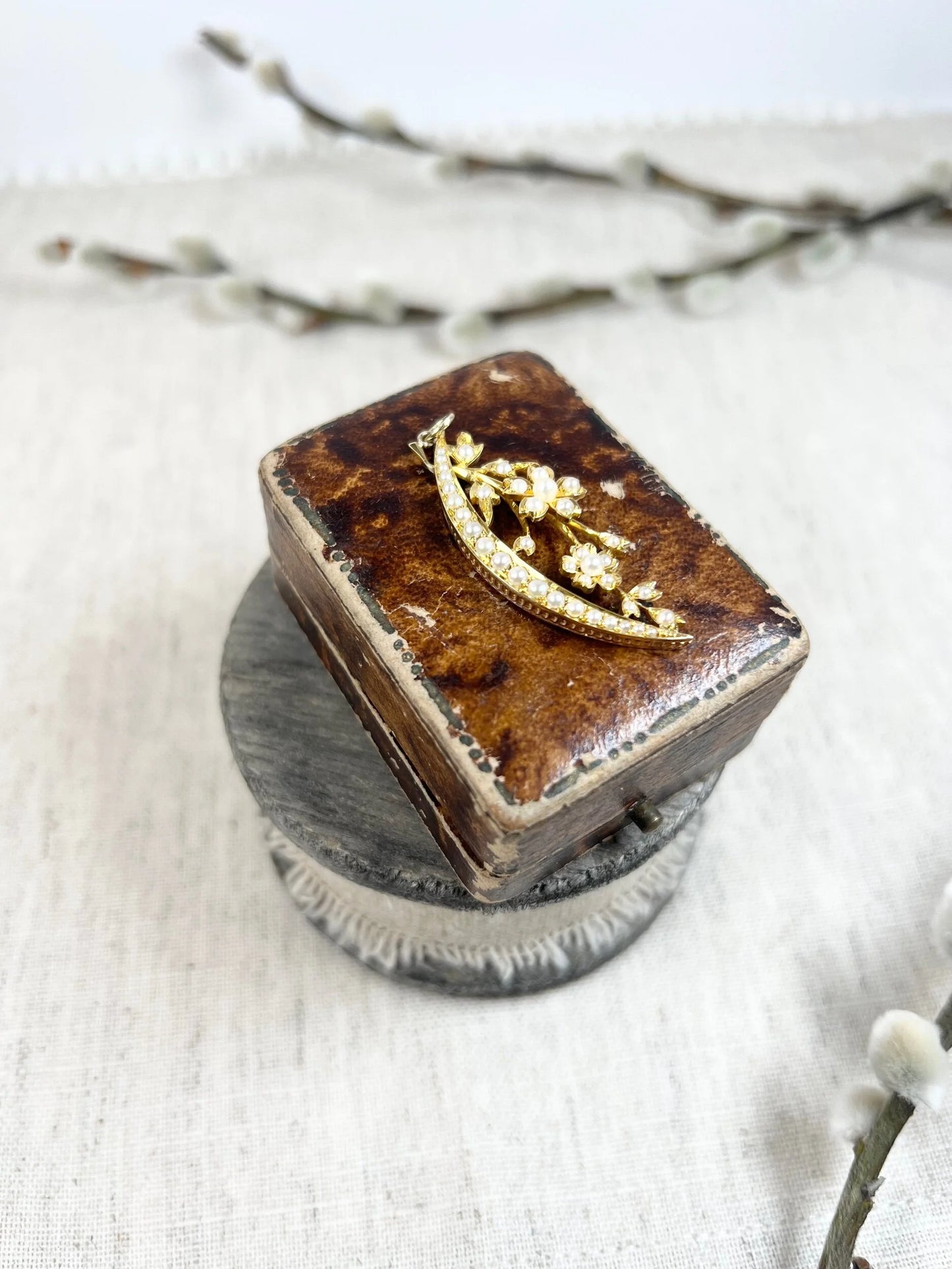 A yellow gold floral crescent pendant with pearls