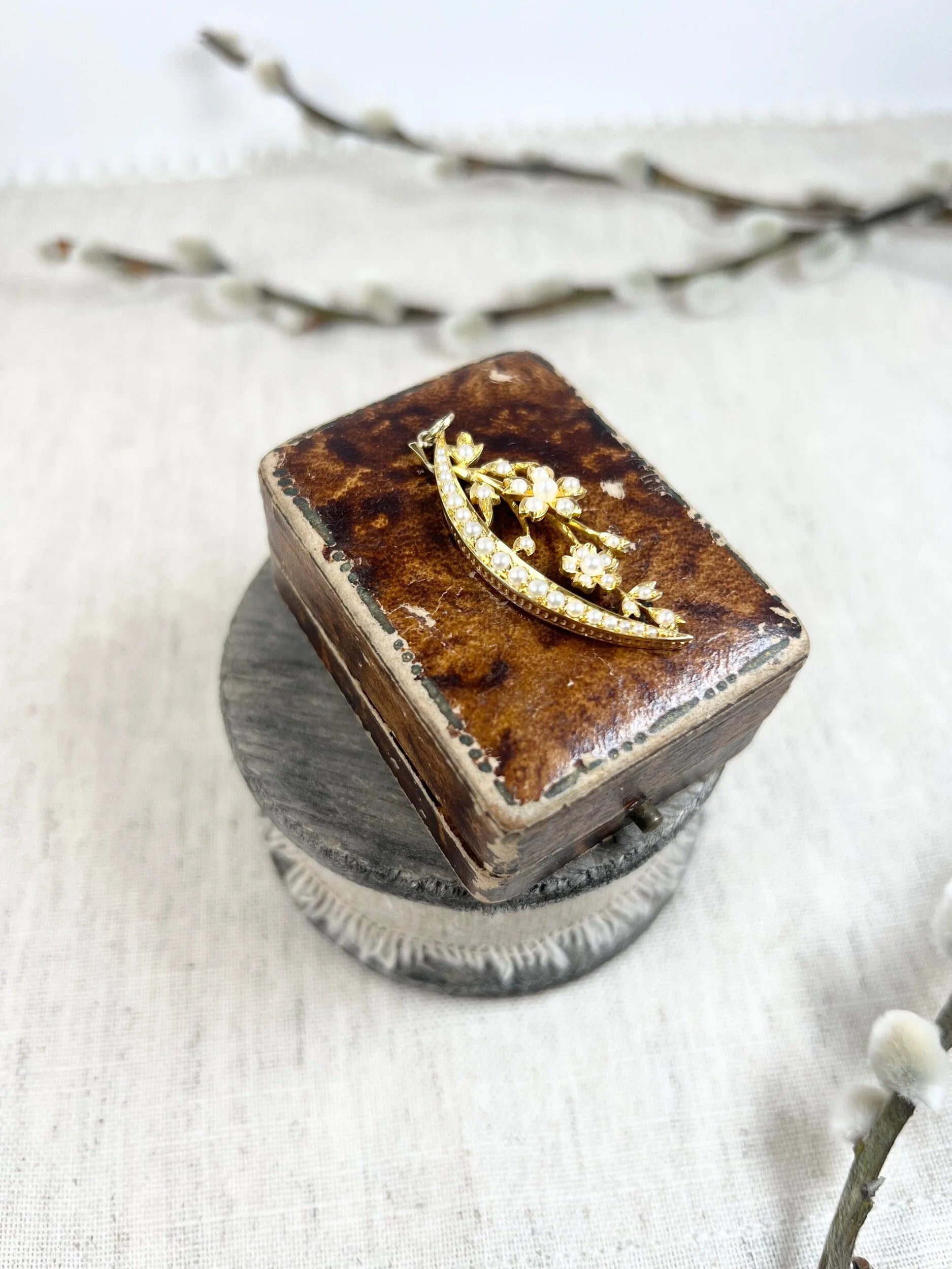 A yellow gold floral crescent pendant with pearls