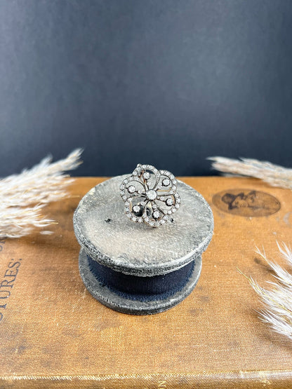 A floral design diamond set pendant/brooch, on an antique box