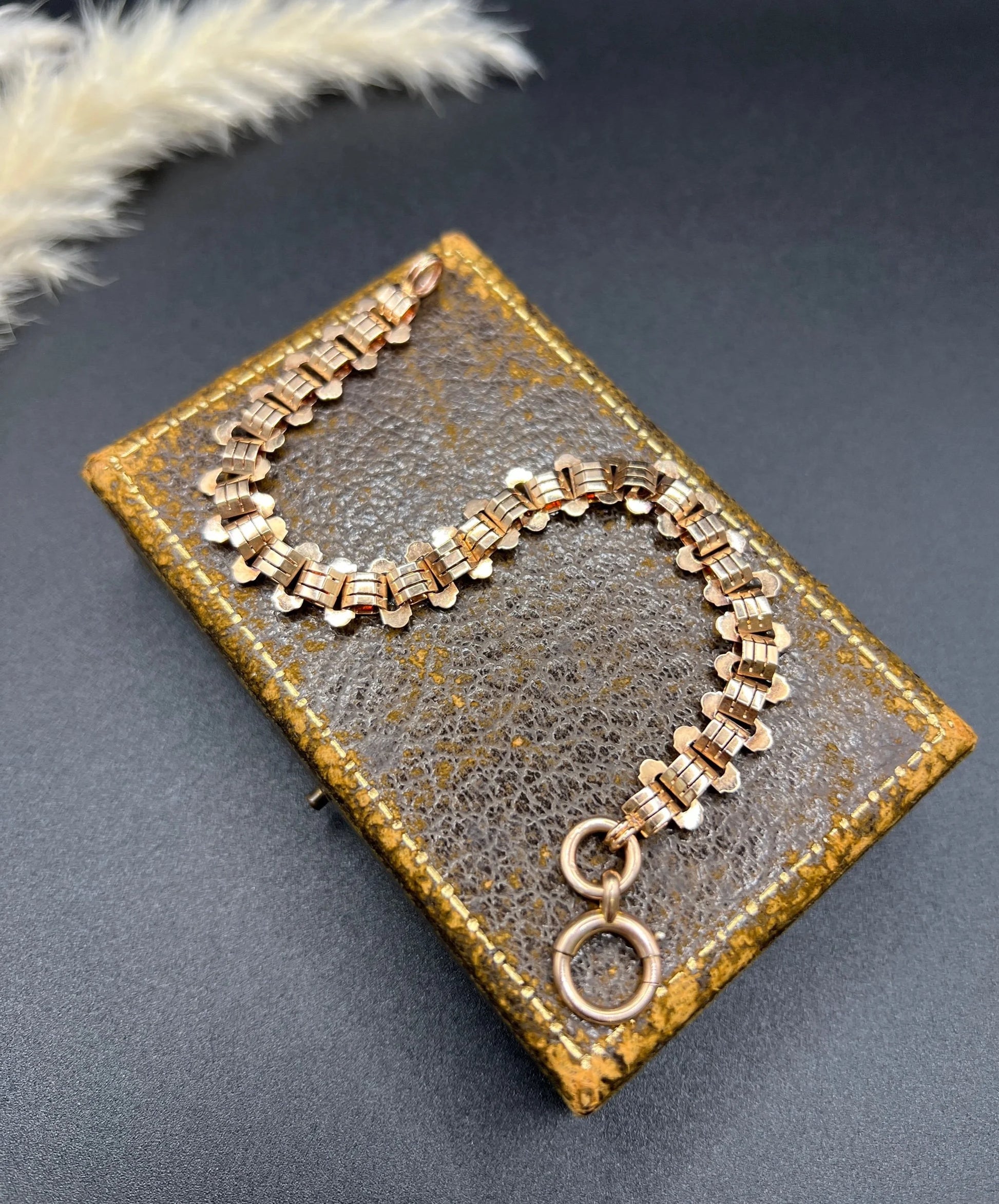 A rose gold fancy link bracelet with a bolt ring clasp