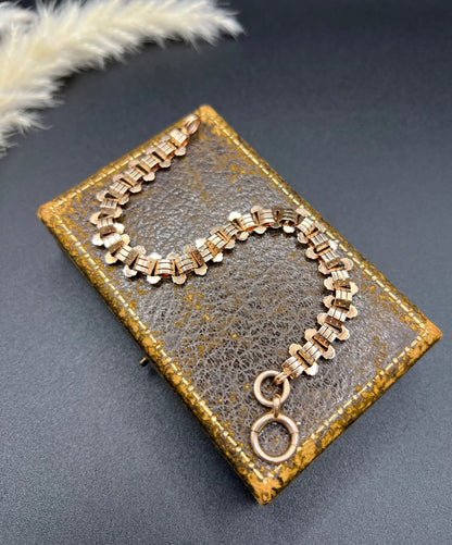 A rose gold fancy link bracelet with a bolt ring clasp