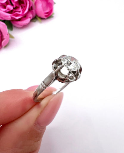 A solitaire diamond ring in platinum, held in a hand